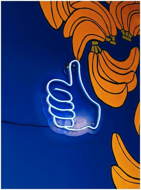 Neon thumbs-up sign on a colorful painted banana w