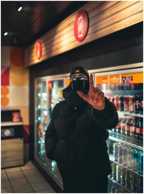 A man wearing a face mask and parka gestures in fr