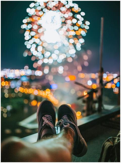 Person enjoying a rooftop view of vibrant firework
