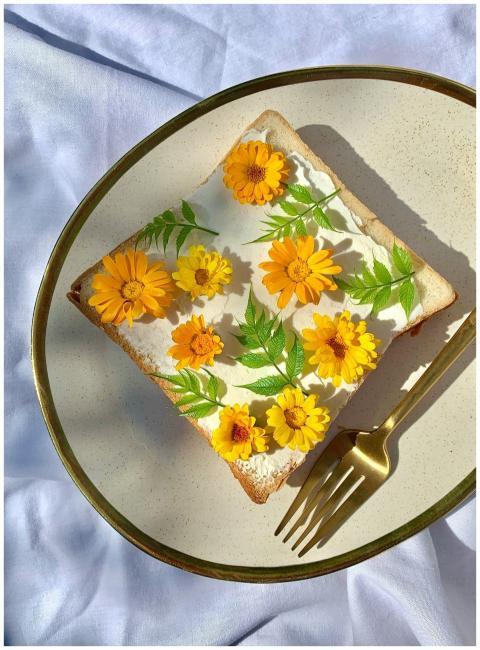 Artistic toast with edible flowers and leaves on a