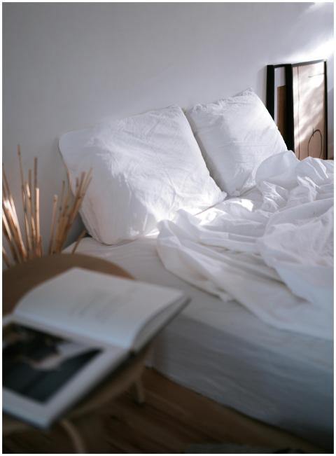 A cozy bedroom setup with white bedding and soft n