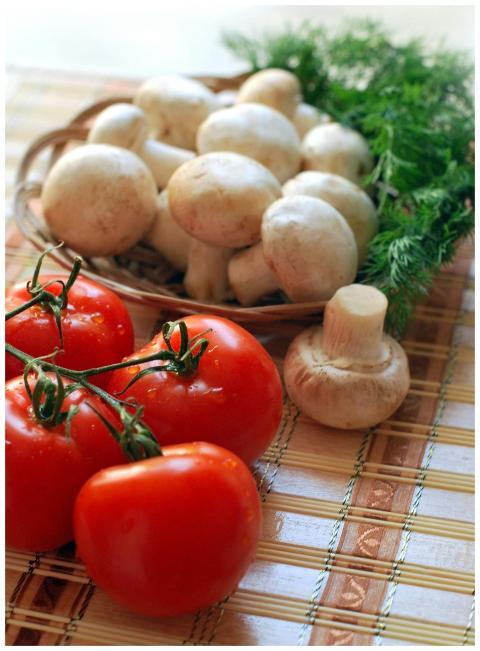 Close-up of fresh tomatoes and mushrooms on a rust
