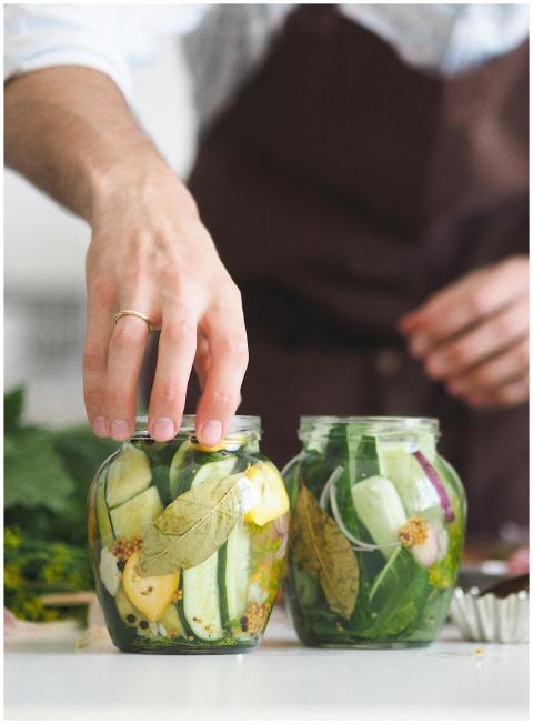 Close-up of hands preparing homemade pickled veget