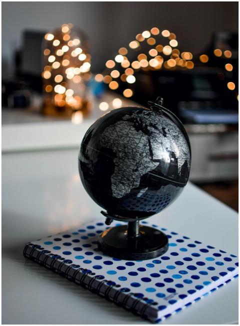 Elegant black globe and notebook against warm boke