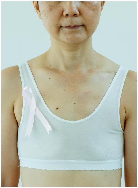 Close-up of a woman wearing a pink ribbon for brea
