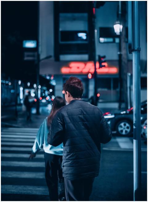 Back view of two people crossing a city street at