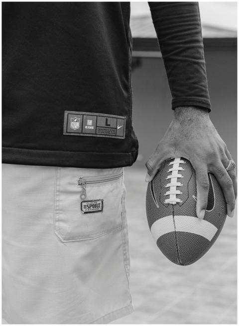 Monochrome photo of an individual holding a footba