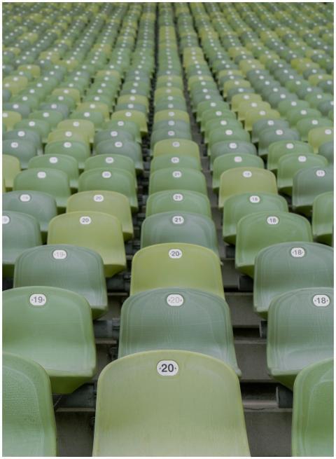 Close-up view of empty green stadium seats with nu