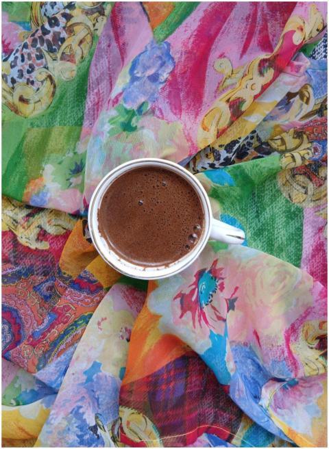 A cup of coffee on vibrant, artistic fabric create