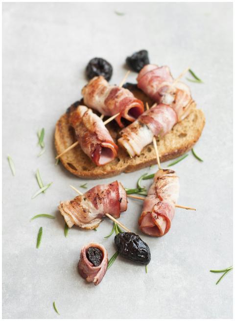 Delicious bacon-wrapped prunes with rosemary on ru