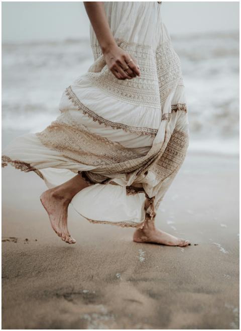 A serene moment of a woman in a flowing dress walk