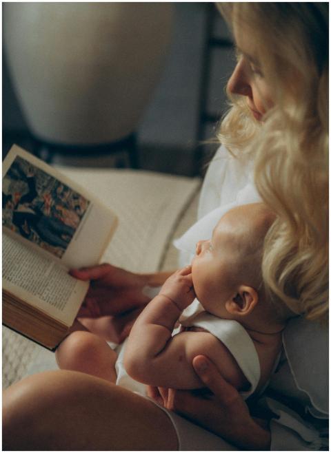 A mother reads to her baby in a cozy indoor settin