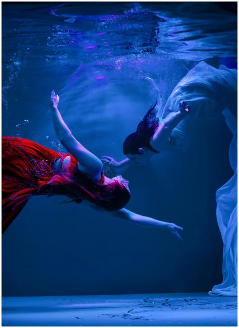 An artistic underwater shot depicting two women in