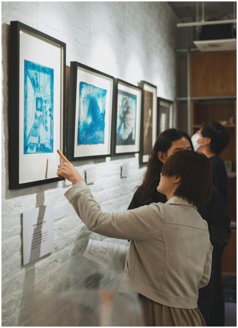 Visitors discuss artworks at a modern gallery in S
