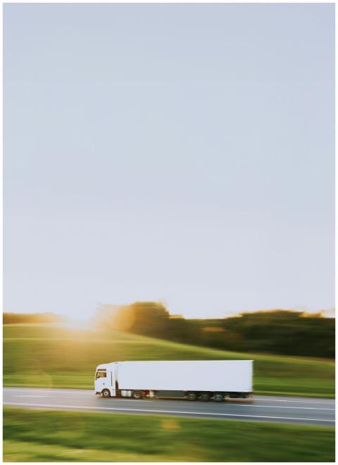 White cargo truck speeding through Vitebsk country