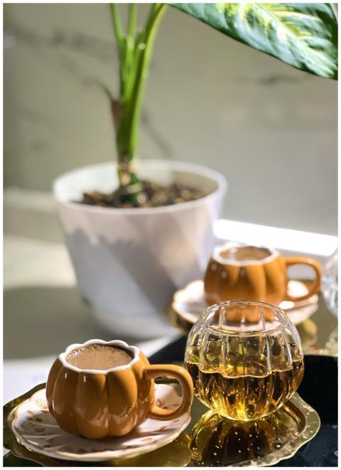 Warm indoor scene with pumpkin-shaped coffee mugs