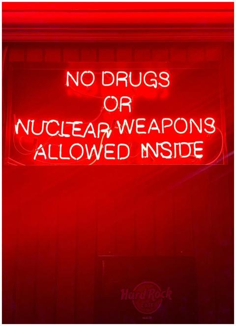 Bright neon sign reading 'No drugs or nuclear weap