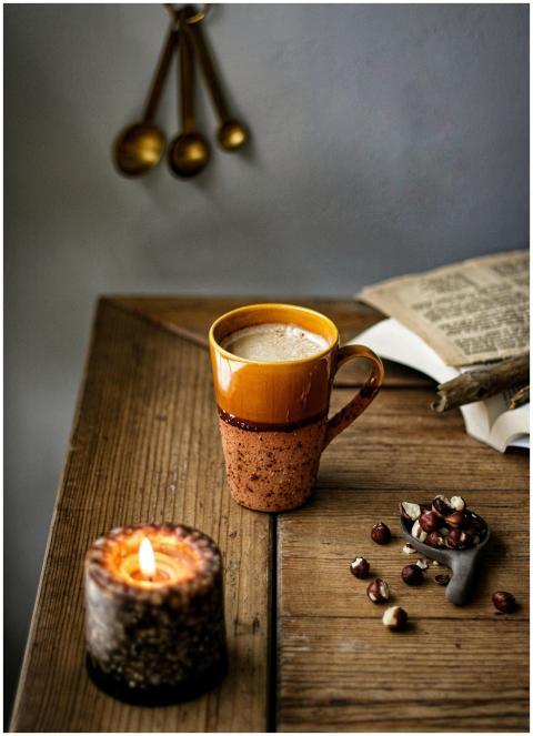 Rustic coffee setup with a candle, creating a warm