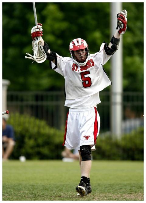 Lacrosse player celebrating a victory with arms ra