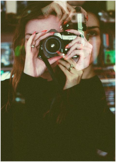 Artistic double exposure of a woman taking a photo