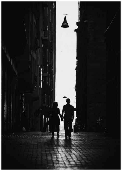 Black and white silhouette of a couple holding han