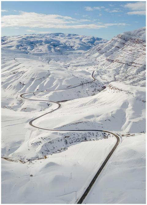 Stunning aerial view of a winding snow-covered roa