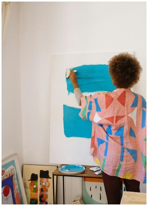 Female artist works on a colorful abstract paintin