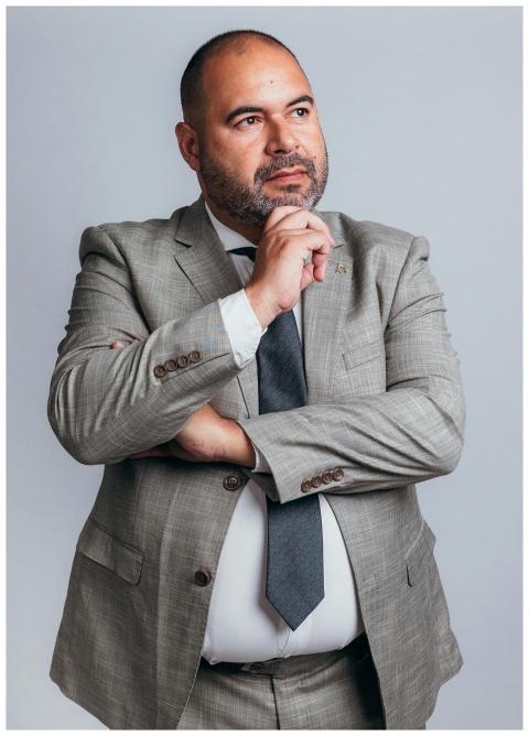 A professional businessman in a grey suit poses th