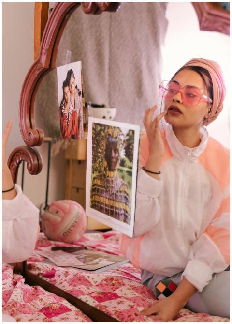 Young stylish female in eyeglasses and turban sitt