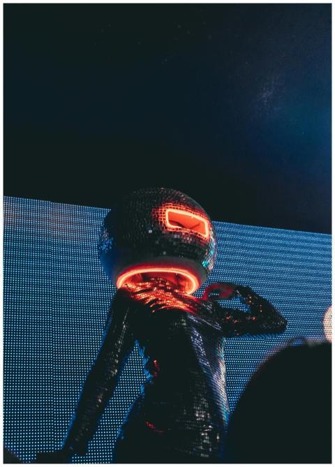 Neon-lit performer in a reflective disco costume a