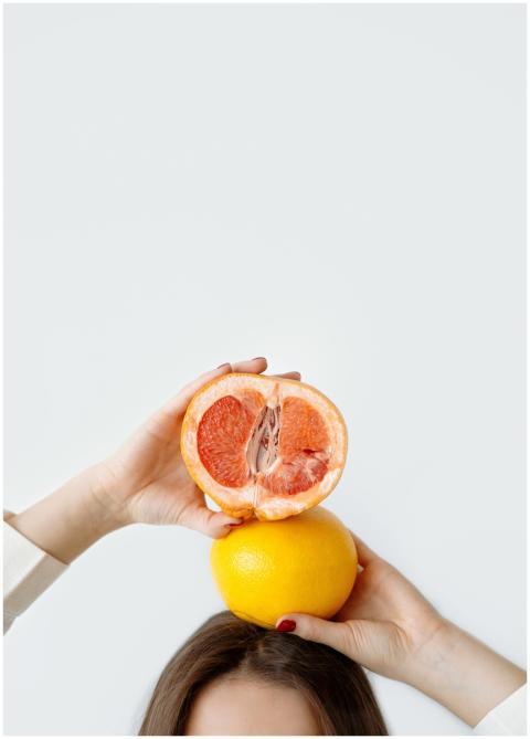 Close-up of hands holding grapefruit and orange ov