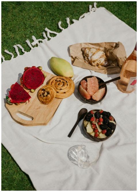 A vibrant picnic setup with fruits, pastries, and