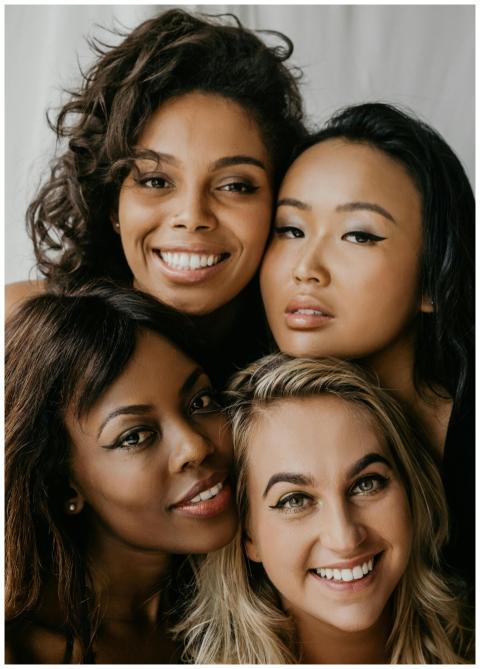 A close-up of four diverse young women smiling and