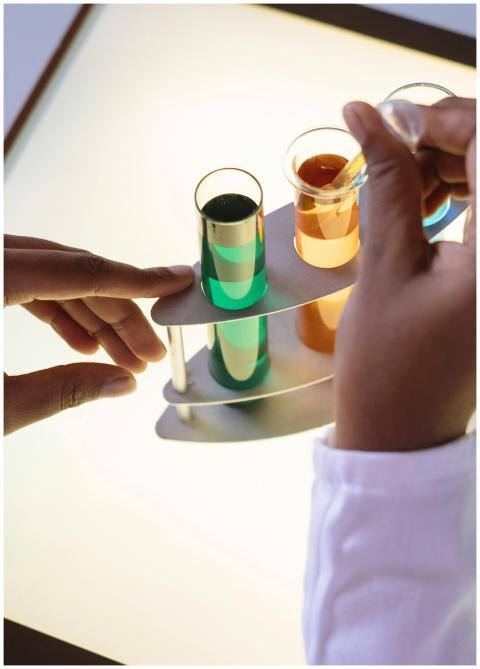 Crop laboratory technician in white uniform using