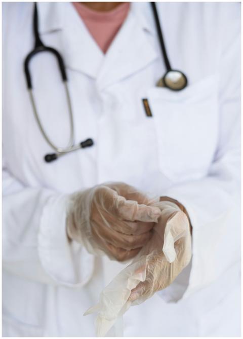 Faceless ethnic medical worker in lab coat and ste