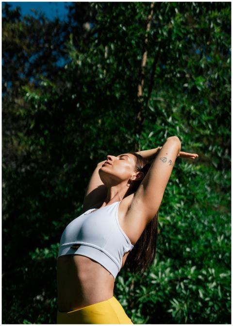A woman in a yoga pose outdoors, symbolizing a hea