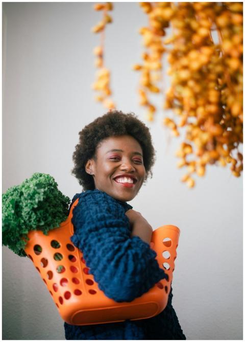 Smiling woman carries fresh green lettuce in an or