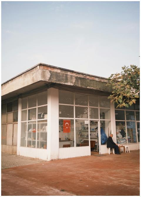 Street view of a shop with Turkish flag and a pers