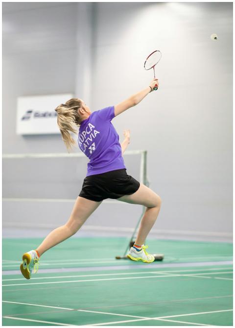 Dynamic action shot of a woman playing badminton i