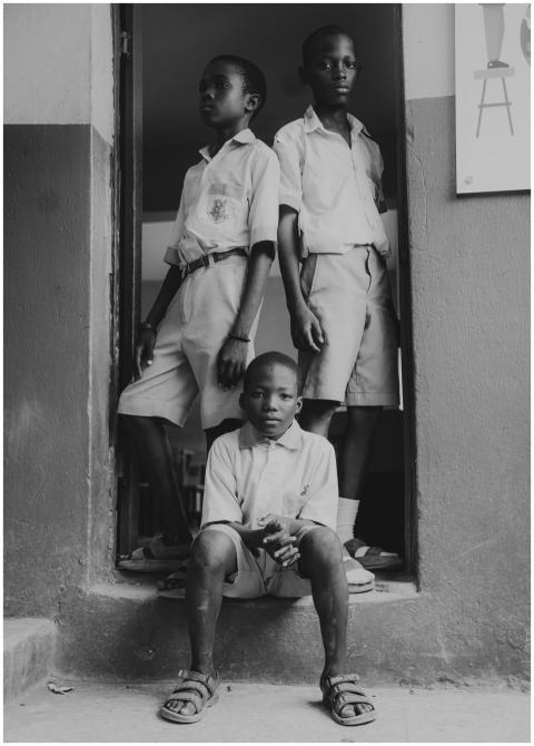 Black and white photo of three schoolchildren in u