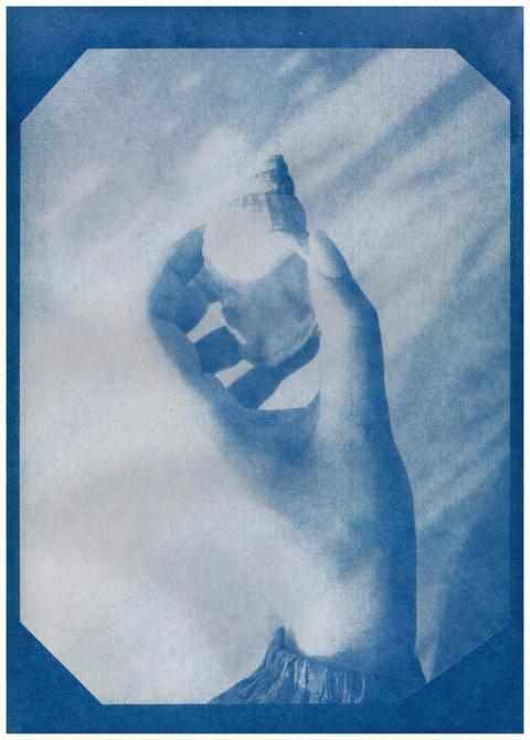 Artistic cyanotype print featuring a hand holding