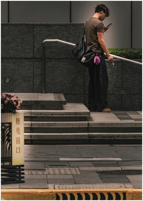 A person on city steps engaged with a smartphone,