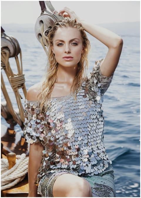 Model posing stylishly on a yacht with sparkling t