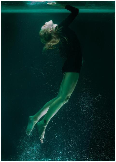 Elegant underwater shot of a woman floating in a s