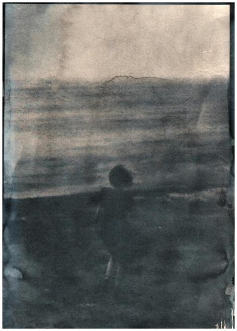 A dramatic cyanotype of a person standing on the b