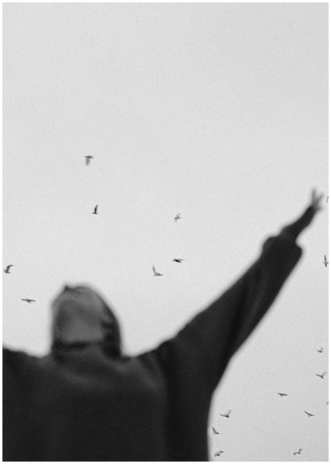 A blurred figure with outstretched arms surrounded