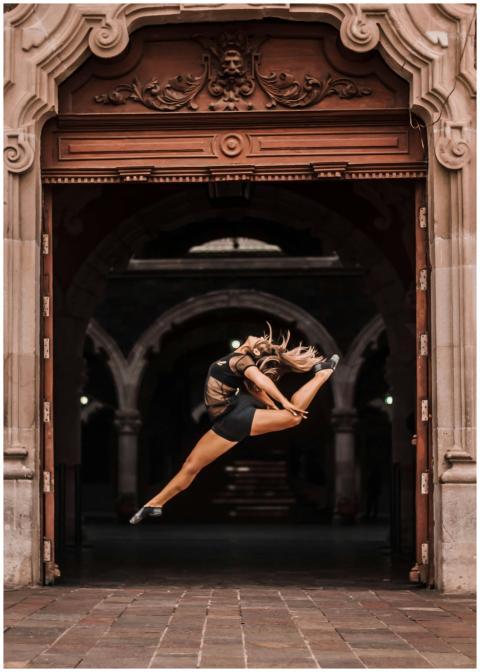 Ballet dancer performing a dramatic jump in a hist