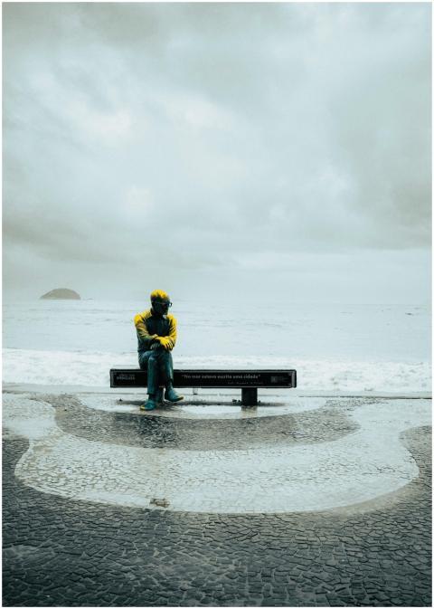 Solitary Figure Sitting Oceanfront