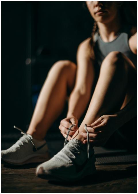 Woman preparing for workout by tying shoelaces in