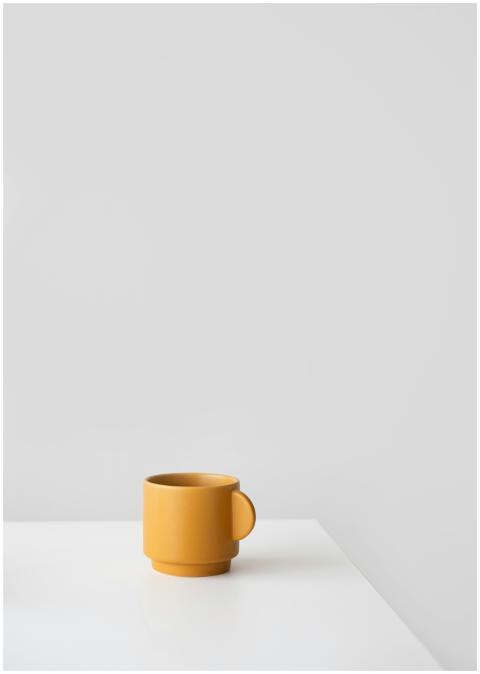 Simple yellow mug against a white background in a